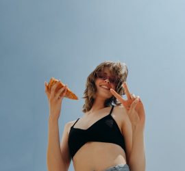 woman holding pizza slice